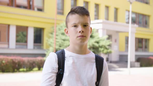 A Caucasian Teenage Boy Shows a Thumb Down to the Camera and Shakes His Head  a School