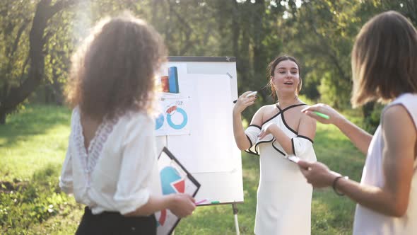 Young Beautiful Woman Explaining Business Strategy in Spring Park Talking to Colleagues in Slow alt