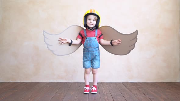 Funny kid playing with toy paper wings. Slow motion