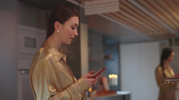 Side View of Woman Using Mobile While Standing on Kitchen alt