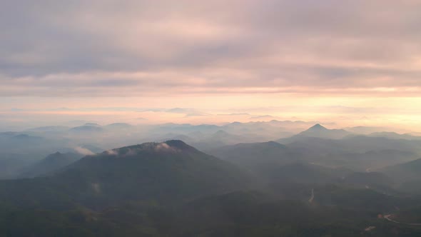 4K Flying through the clouds above mountain tops alt