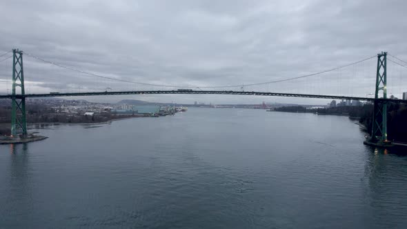 Lions Gate or First Narrows Bridge on cloudy day, Vancouver in Canada. Aerial forward alt