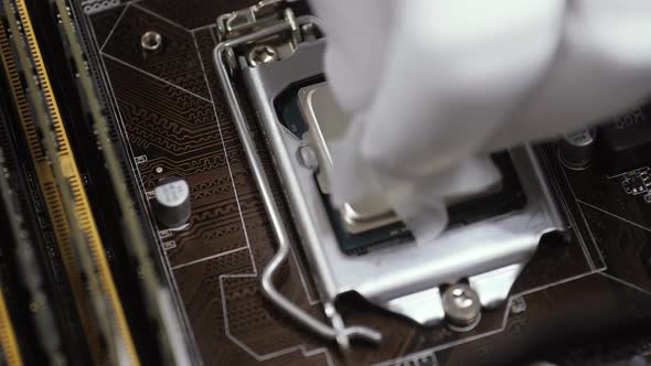 Close Up Engineer Hand in White Antistatic Gloves Removes Dried Thermal Paste alt