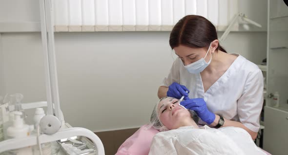 Female Cosmetologist Makes Rejuvenating Botox Anti Wrinkle Injections on the alt