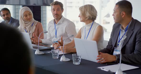 Businessman talking on a panel of delegates at a conference alt