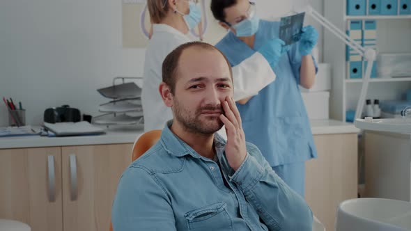 Portrait of Patient with Toothache Looking at Camera in Dentistry Office alt