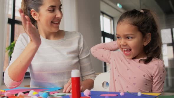 Daughter with Mother Making High Five at Home alt