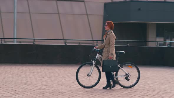 Redhead businesswoman going near bicycle