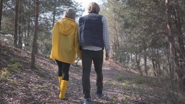 Couple in Love Holding Hands Walking in the Spring Forest alt
