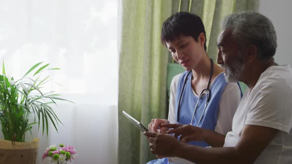 Nurse helping a senior man in retirement house alt