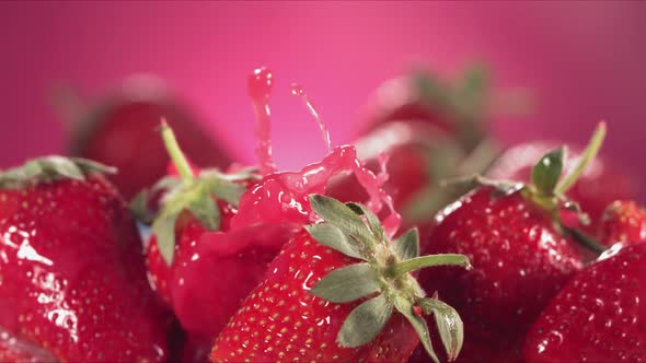 Slow Motion Shot of Strawberry Juice Splashing Through Strawberries alt