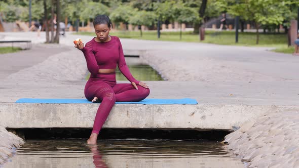 Confident Athletic Millennial African Girl in Sportswear Relaxing on Yoga Mat After Workout alt