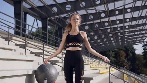 Young Woman in Fitness Clothes Doing Phisical Exercises with Jump Rope During Sport Training alt