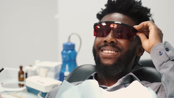 Side Shot of a Young Man Whitening His Teeth at the Dentist alt