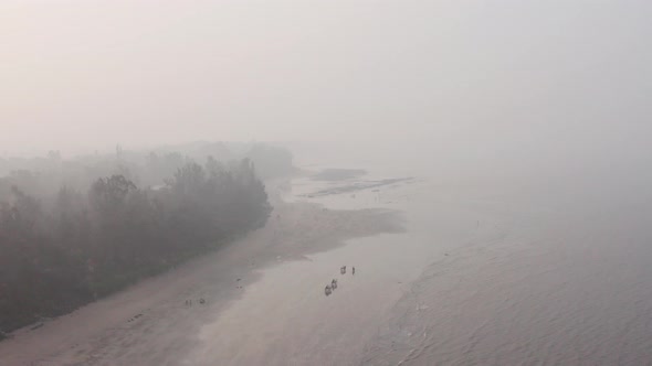 decending drone shot of illegal bullock cart racing on a beach in India alt