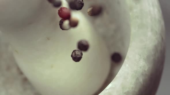 Granite Mortar and Colored Pepper Grain Spice Species Falling in Slow Motion alt