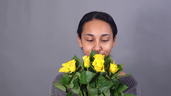 Closeup of Smiling Mixedrace Young Pretty Woman with Bunch of Yellow Roses alt