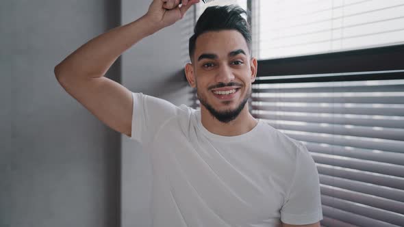 Arabian Spaniard Arab Man Looking at Camera Combing Hair with Hairbrush Getting Ready to Date Work alt