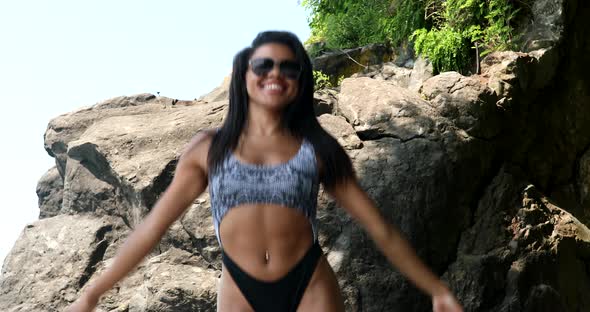 Summer vacation black woman having fun on beach walking relaxing in the sun wearing bikini.