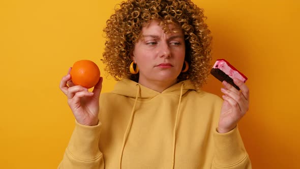 Portrait of Frustrated Hesitating 30s Woman Wearing Casual Jumper Holding Sweet Cake and Fresh alt