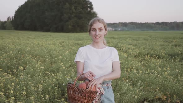 A Beautiful Country Side Girl Holding a Basket of Ripe Peaches. Organic Farming Fruits alt
