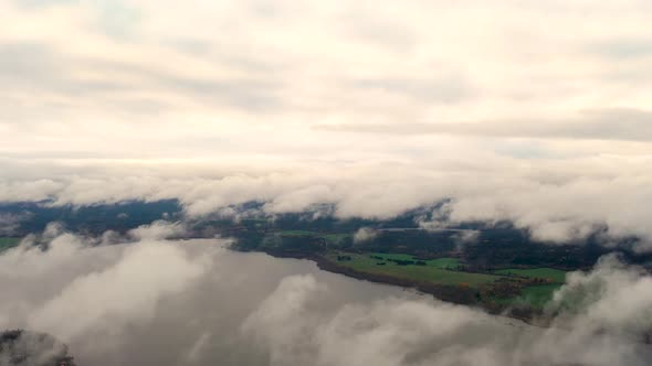 Aerial view running clouds over green forest. Time lapse white clouds