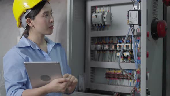 Female engineer checking on electric system in construction site