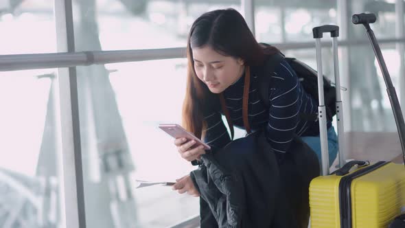 Young traveler female use smartphone while waiting at airport