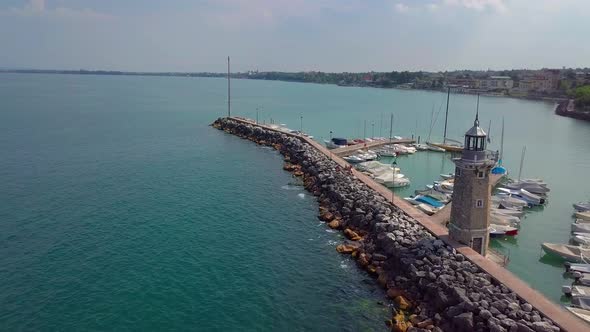 Aerial View of Boats and Lighthouse in Lake Garda, Italy alt