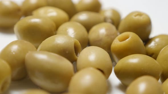 Lot of green european table olives served on the plate slow tilt 4K 2160p 30fps UltraHD video - Olea alt