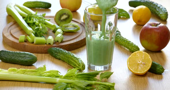 Pouring Organic Freshly Squeezed Green Vegetable and Fruit Smoothie Into the Glass alt