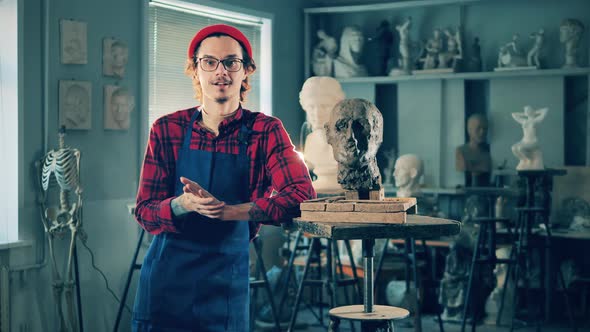 Sculptor is Standing Next to the Clay Head Made By Him alt