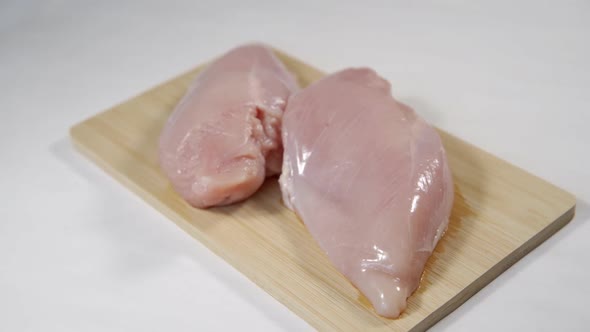 Fresh Raw Chicken Breast on a Board