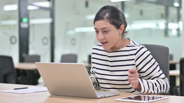 Beautiful Indian Woman Celebrating Success on Laptop in Office  alt