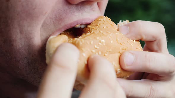 Mouth of an Adult Male Greedily Eating a Hamburger alt