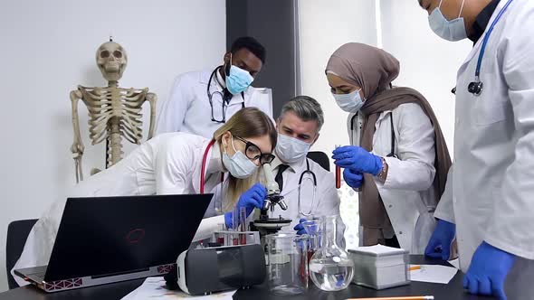 Scientists Working in Laboratory of Chemistry Classroom with Microscope and Test Tubes, Analysing alt