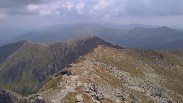 People hike on a trail to Pietrosu Rodnei on the mountain ridge, Romania alt