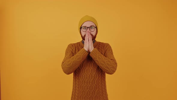 Surprised Man Covering His Face with His Palms  Orange Background alt