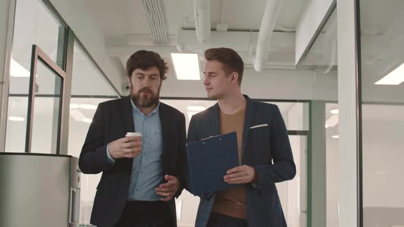 Two Caucasian Businessmen Going along Office alt