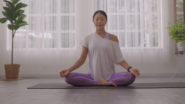 After waking up at home, a woman does morning yoga alt