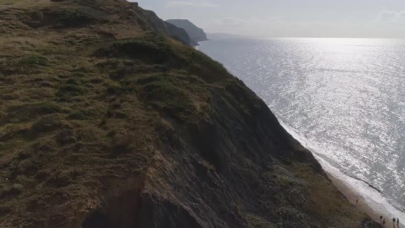 Aerial over the cliffs at Charmouth. Tracking close over the edge of the cliff to the east of the vi alt