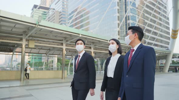 Group of young office businesspeople wear mask, walking outdoor in city with new normal lifestyle. alt