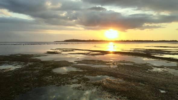 Colorful landscape aerial view of lighting ocean,hills and sunset in background between clouds. alt