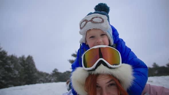 Winter Activities Happy Woman with Little Boy Have Fun Sledding Down Hill in Winter Forest During