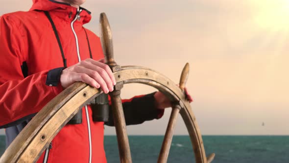 Captain Holding Hands on Ship Rudder and Looking in Binoculars For The Way Forward.