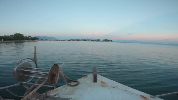 Point of view from inside of a sailing fishing boat. Sailing forward into the sunset. Calm water out alt