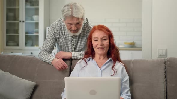 A Senior Couple Uses a Laptop During an Online Video Call alt