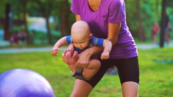 Mother Doing Gymnastics with Baby in Park alt