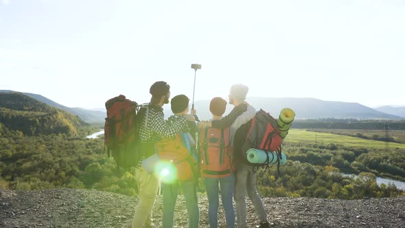 Attractive Couple Posing on the Smart Phone Camera in the Mountain. alt
