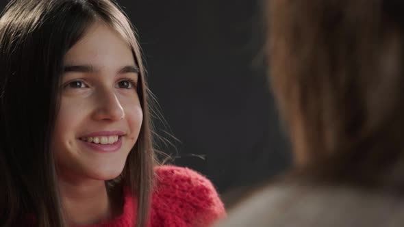 Close Up of a Mother and Daughter Sitting on Sofa at Their Home and Talking alt